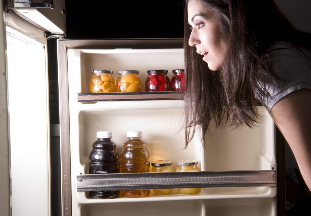 post-indústria-mulher-olhando-dentro-da-geladeira
